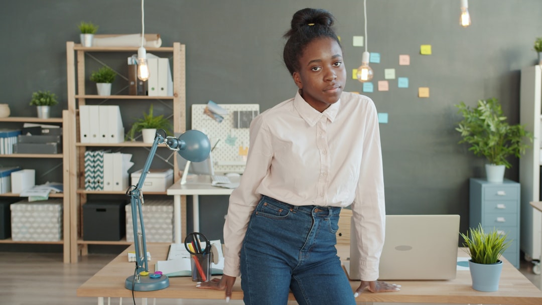 A young woman sits at a desk in an office.